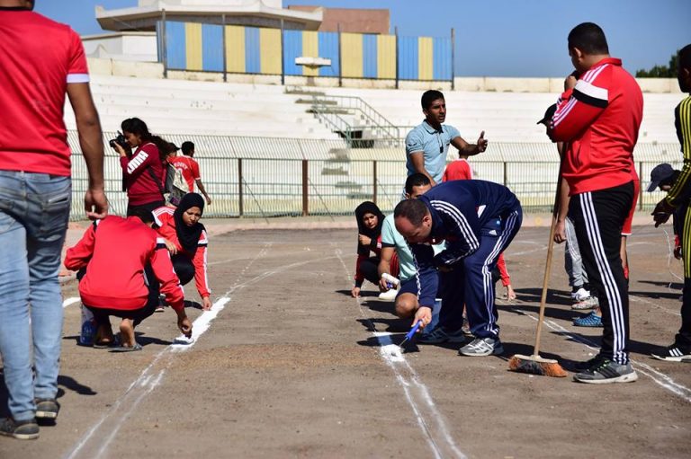 طلاب التربية الرياضية يقومون بتخطيط مضمار العاب القوي باستاد سوهاج